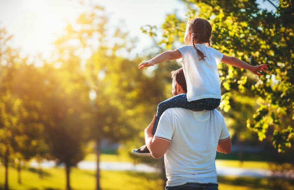 Padre alzando hija en hombros